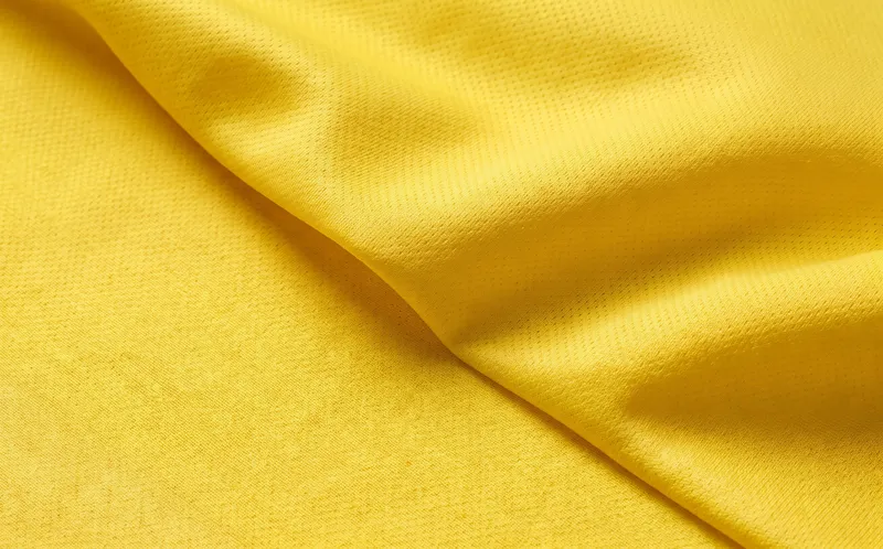 Close da malha dryfit amarela com textura micro furada